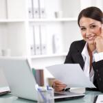 Attractive young businesswoman working on documents in office